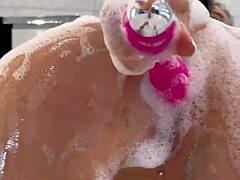 Monika Fox plays with pink toy in foamy bathroom