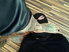 En tatoveret MILF dominerer sin fodslave i en varm barfodsvideo